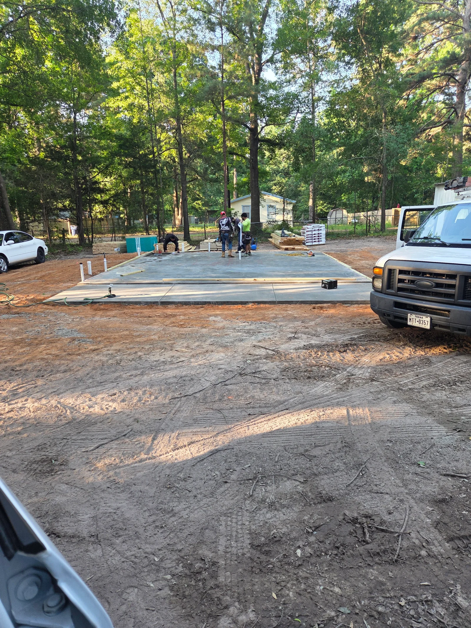 Concrete foundation pad with white layout markers on prepared gravel subgrade