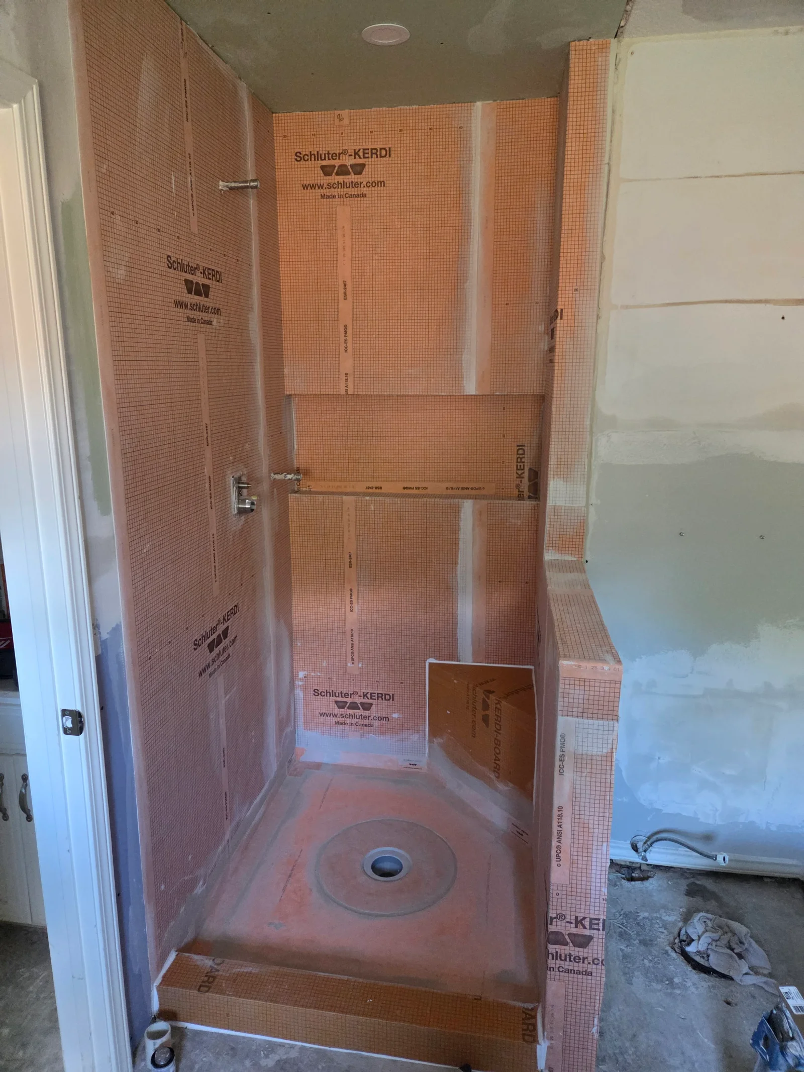 Shower stall with Schluter-KERDI waterproofing membrane and orange tile substrate installed